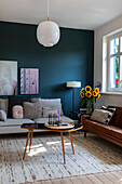 Living room with turquoise blue accent wall and bouquet of sunflowers on side table