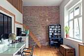 Study with brick wall, light-coloured wooden floor and retro decor
