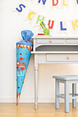 School cone with fire brigade motif next to grey desk