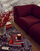 Red couch and marble table with books and candle in the modern living room