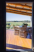 Covered terrace area with rattan chairs and views of the countryside