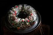  Christmas decoration with ice ring filled with holly, cones and needles 