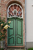  Front door with climbing roses on a historic house 