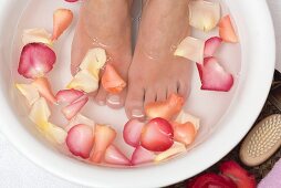 Woman bathing her feet in rose petal water