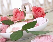 Pink roses and rose soaps in dish of water