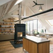 Offener Wohn/Essraum im ausgebauten Dach mit freistehendem Schwedenofen und Glasfront zur Dachterrasse