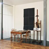 Antique wooden table, Thonet chairs, tailors' dummy and old easel in corner of loft apartment