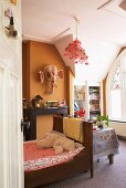 Bright child's bedroom with Art Nouveau window, wooden bed and whimsical elephant mask