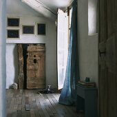 Rustikaler Eingangsbereich mit Leinenvorhang, Balkendecke und alter Holztür