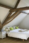 Gemütliche Schlafecke im Schlafzimmer, mit Doppelbett unter der Dachschräge