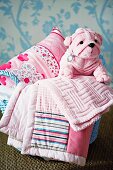 Pink blankets, cushion & cuddly plush dog in basket