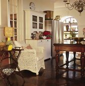 Dining room in mixture of styles with traditional furnishings, collectors' items and modern kitchen appliances with stainless steel fronts