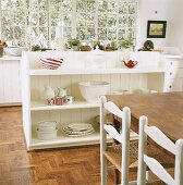 Geschirr im weißen Regal hinter Holztisch