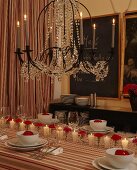 Festively set table below chandelier