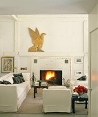 Galeriewohnung mit weißer Couchgarnitur vor Kamin aus Backstein
