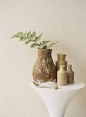 Vases of table with sprig of fern
