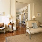 Wohnraum mit griechischen Wandelementen und barocker Sitzbank auf einem Rattanteppich