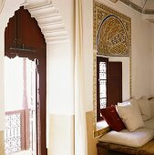 Ausschnitt eines orientalischen Zimmers mit aufwändig ornamentiertem Wandbild und Torbogen um die Balkontür