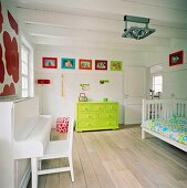 Neongrüne Kommode und bunte Wanddekoration in einem weissen Kinderzimmer