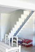 Eine weiße, moderne Treppe in einem holzvertäfelten Wohnraum