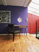Ein schlichter Arbeitsplatz im hellen Dachgeschosszimmer mit Oberlicht und lebendigem Rot-Violett Kontrast