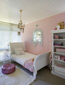 Niedliches Kinderzimmer mit weißem Bideremeierbett und Vintageregal vor einer rosafarbenen Herzchentapete