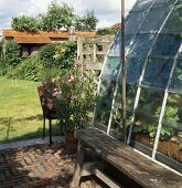 Ländliche Terrasse und Glasanbau mit Blick auf den Garten