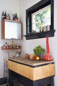 Blick in Küchenecke mit Rolltürschränkchen & rustikaler Ablage aus Holz unter Fenster mit schwarzem Festerrahmen