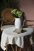 Hortensien in Kanne und Bücher auf Tisch