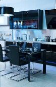 Küche in Schwarz mit Hängeschrank, Deckenleuchte, Esstisch & freischwinger Stühlen