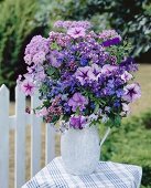 Jug of purple flowers out of doors