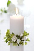 White candle with wreath of lady's mantle and white roses