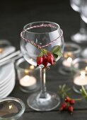 Rose hips tied on wine glass (decorative idea)