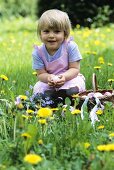 Kleines Mädchen mit Ostereiern in einem Korb