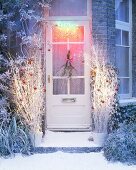 Blick auf weihnachtlich dekorierte und beleuchtete Haustür