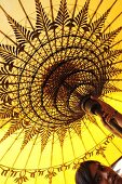 Frau hält gelben gespannten Sonnenschirm