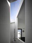 A view through a window-like opening in an anteroom and a skylight in a newly built house