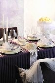 Festlich gedeckte Hochzeitstafel mit violetten Tischläufern und Schleierdeko