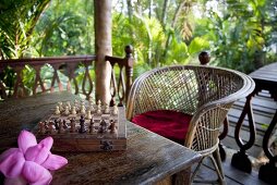 A chess board set out on the terrace in tropical surroundings