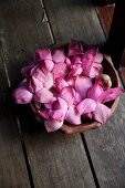 A bowl of purple lotus flowers on a wooden floor