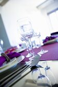 Weingläser auf einem violetten Tischläufer in gekippter Perspektive aufgenommen