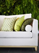 Sofa upholstered in white with pillows