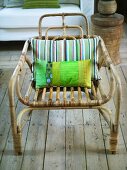 Rattan chair with striped pillow on rustic wood flooring
