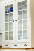 White lacquer crockery cupboard with glass panes separated by glazing bars