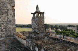Verwittertes Steintürmchen auf Steinmauer mit Blick auf die italienische Landschaft