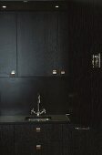 Spüle mit Armatur und Kücheneinbauschränke in schwarzer Holzausführung