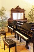 Zwei Klaviere mit Klavierbank im Musikzimmer