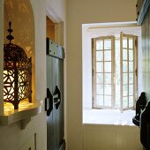 Flur im rustikalen Landhaus - orientalische Laterne in Wandnische und geöffnetes Sprossenfenster