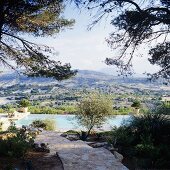 Weg mit Natursteinplatten im Mediterraner Garten mit Pool und beeindruckende Aussicht auf die spanische Landschaft