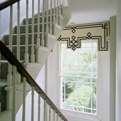 Sprossenfenster mit Schabracke im weißem Treppenhaus